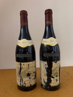 two bottles of wine sitting on top of a table next to each other
