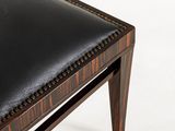 a black leather bench with wooden legs and a black seat