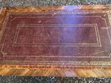 a wooden table with a leather cover on top of it