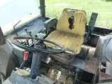 a tractor that is sitting in the grass with a steering wheel