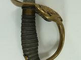 a sword with a gold handle on a white surface