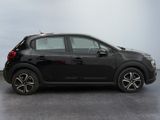 the small black car is parked on the concrete floor