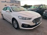 une Ford Monde blanche garée devant un immeuble