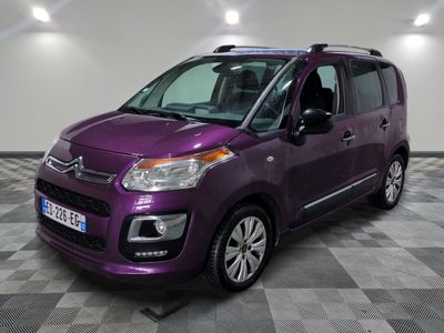 La camionnette violette est garée sur un sol à damier dans un garage.