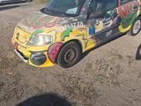 a car that has been painted with graffiti on the side of the road