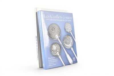 un livre sur lequel sont représentées plusieurs cuillères en argent