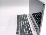 a white laptop with a black keyboard on a white table