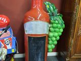 une bouteille de sauce piquante par terre, à côté d'un tas de jouets