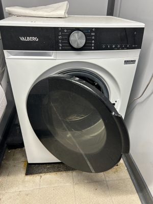 a washing machine that is sitting in the corner of a room