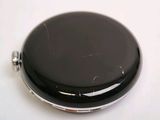 an image of a black pocket watch on a white surface