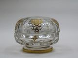 a small glass box with a gold decoration on it