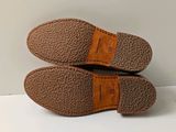 pair of brown slippers on a white surface with a white background