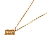 a close up of a gold necklace with a knot on a chain