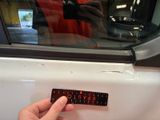 a person taking a picture of a sticker on the door of a car