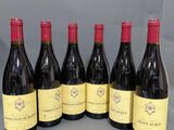 six bouteilles de vin rouge alignées sur une table