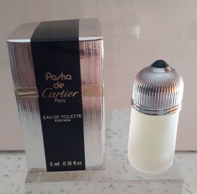un flacon de parfum posé sur un comptoir à côté d'une boîte