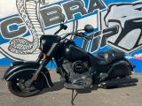 une moto noire garée devant une fresque murale