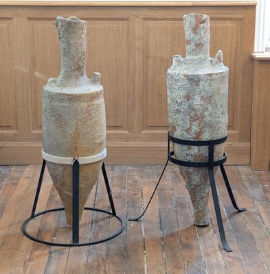 deux grands vases posés sur un meuble dans une pièce