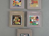 four nintendo game cartridges sitting on top of each other on a table
