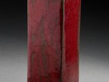 un vase rouge posé sur une table