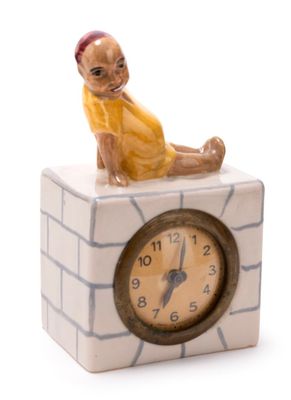 a figurine of a man sitting on top of a clock