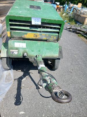 une tondeuse à gazon verte garée sur le bord de la route