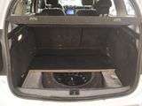 the back of a car with the trunk open and a speaker in the trunk