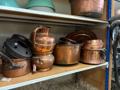 de nombreuses casseroles et poêles rangées sur une étagère dans une pièce
