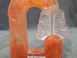 an orange sculpture of a man and woman sitting on a bench