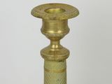 a gold colored candle holder on a white table