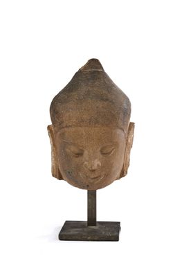 statue représentant une tête de Bouddha posée sur un socle, sur fond blanc