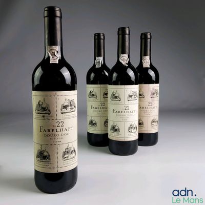 quatre bouteilles de vin sont alignées sur une table