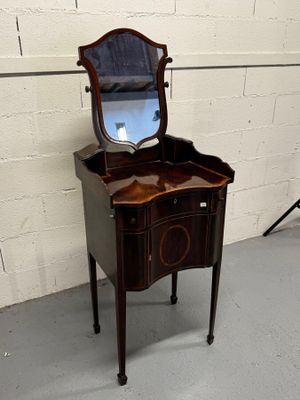 une petite coiffeuse en bois surmontée d'un miroir