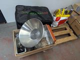 a large metal bowl sitting on a pallet next to other items