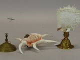 a crab that is sitting next to a candle holder