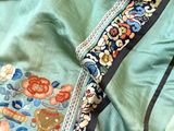 a close up of a shirt and a pair of scissors on a bed
