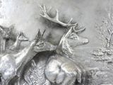 a silver plate with a picture of a herd of deer on it