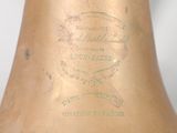 an old brass bell with a stamp on it