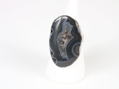 a picture of a black and white ring on a white stand