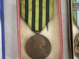 three medals and a medal in a box on a white surface
