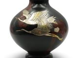 un vase sur lequel est peint un oiseau sur fond blanc