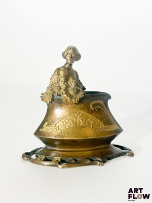 un vase en or surmonté d'un oiseau