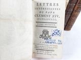 an old book that is open on a white surface