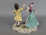 two figurines of a man and a woman holding hands