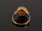 a close up of a gold ring with a red stone in it