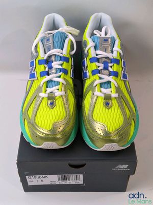 a pair of yellow and blue running shoes on top of a box