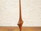 wooden sculpture on a wooden table with a white wall in the background