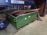 une poubelle verte contenant beaucoup de bois