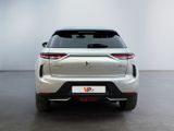 the rear end of a silver suv parked in a white room