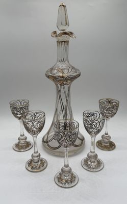 four wine glasses and a decanter on the table